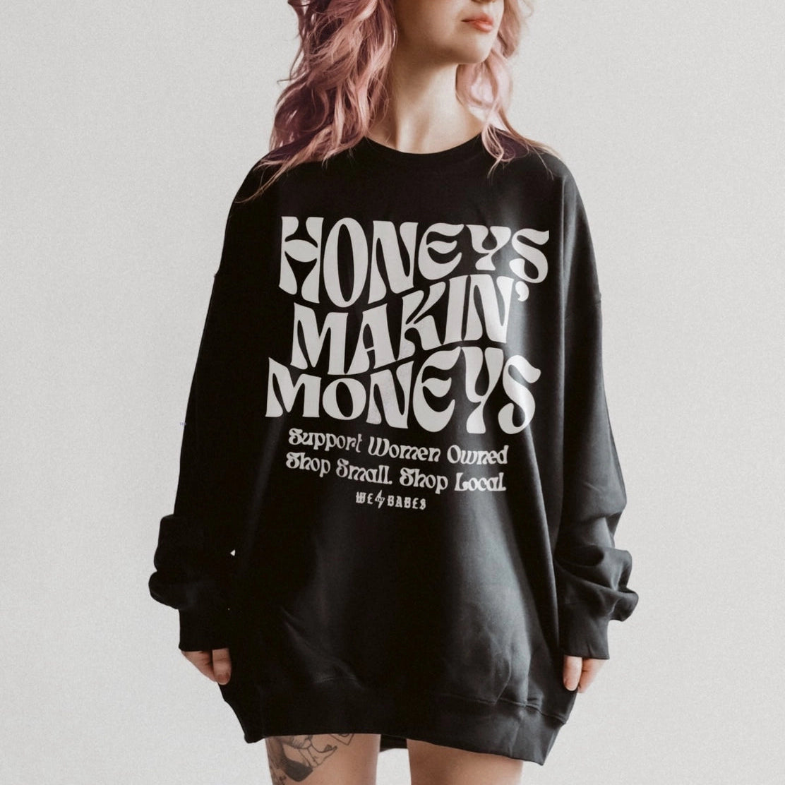 Person wearing a black sweatshirt with text on a plain background